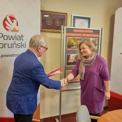Marcelina Dąbrowska odbiera dyplom i nagrodę z rąk Starosty Toruńskiego
