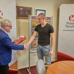 Kacper Paziewski odbiera dyplom i nagrodę z rąk Starosty Toruńskiego
