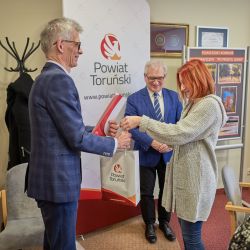 Aleksander Grzelak odbiera zestaw upominków z rąk jurorki konkursu