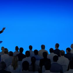 corporate-businessman-giving-presentation-large-audience(1)