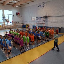 zdjęcie przedstawia halę sportową na której stoi 9 drużyn dziewcząt